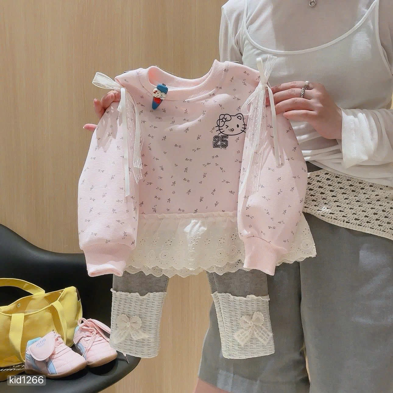 Hello Kitty sweatshirt with grey leggings.